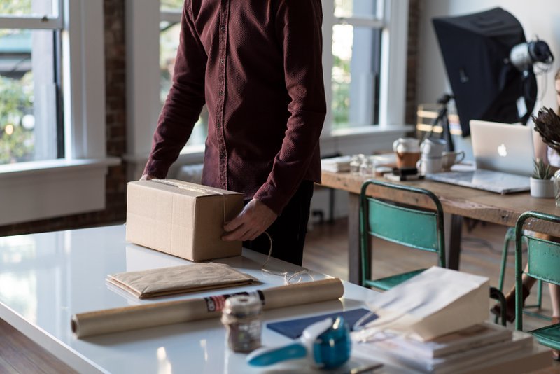 man packing a box package at work