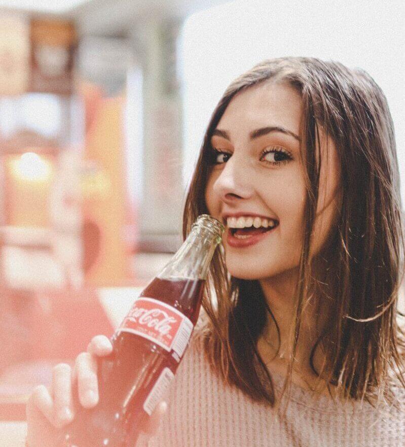 Smiling-woman-holding-Coke-bottle