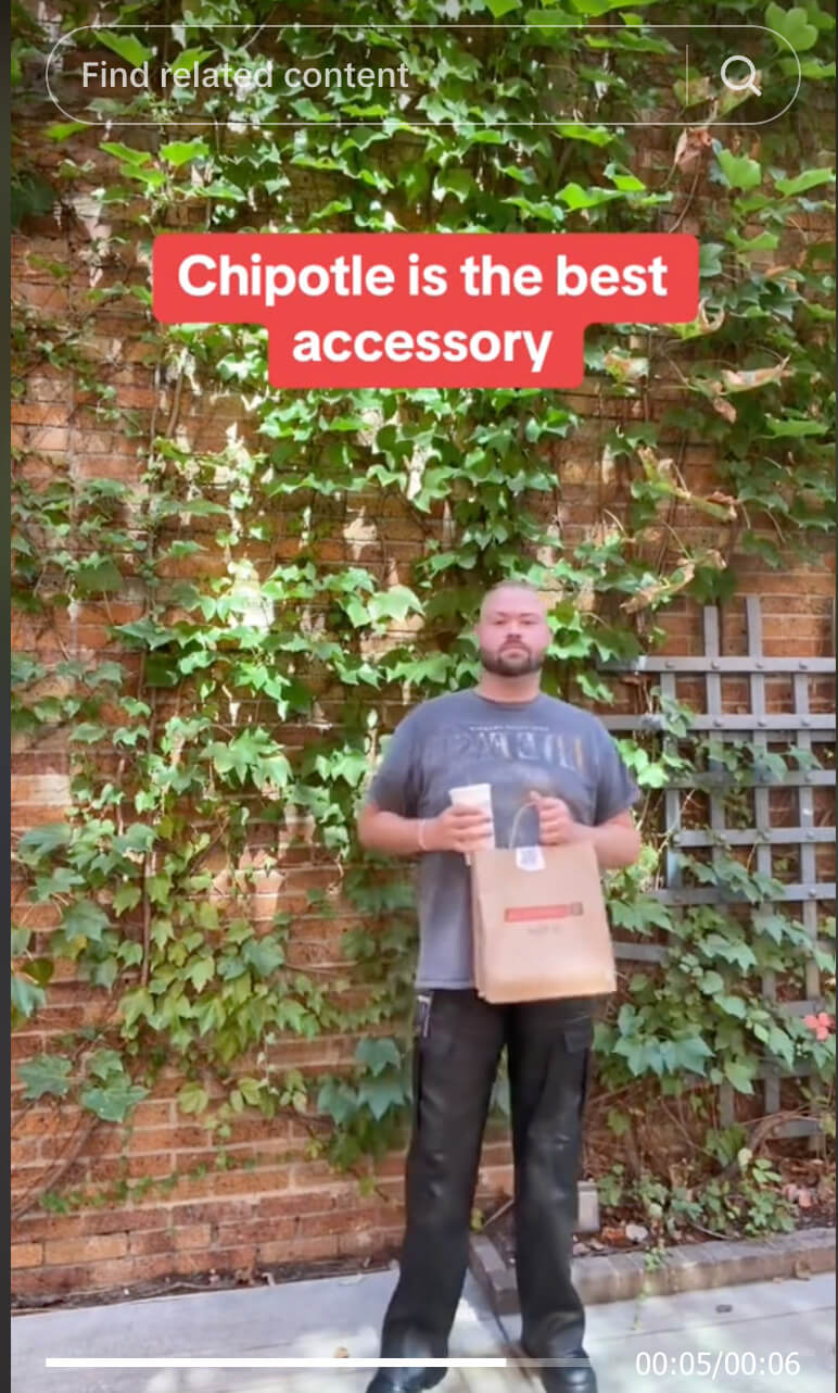 a man holding a paper bag and a bag of chips