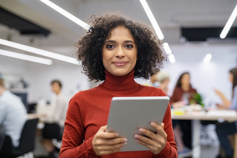 a business woman specialized in google ads holding a tablet in an office setting